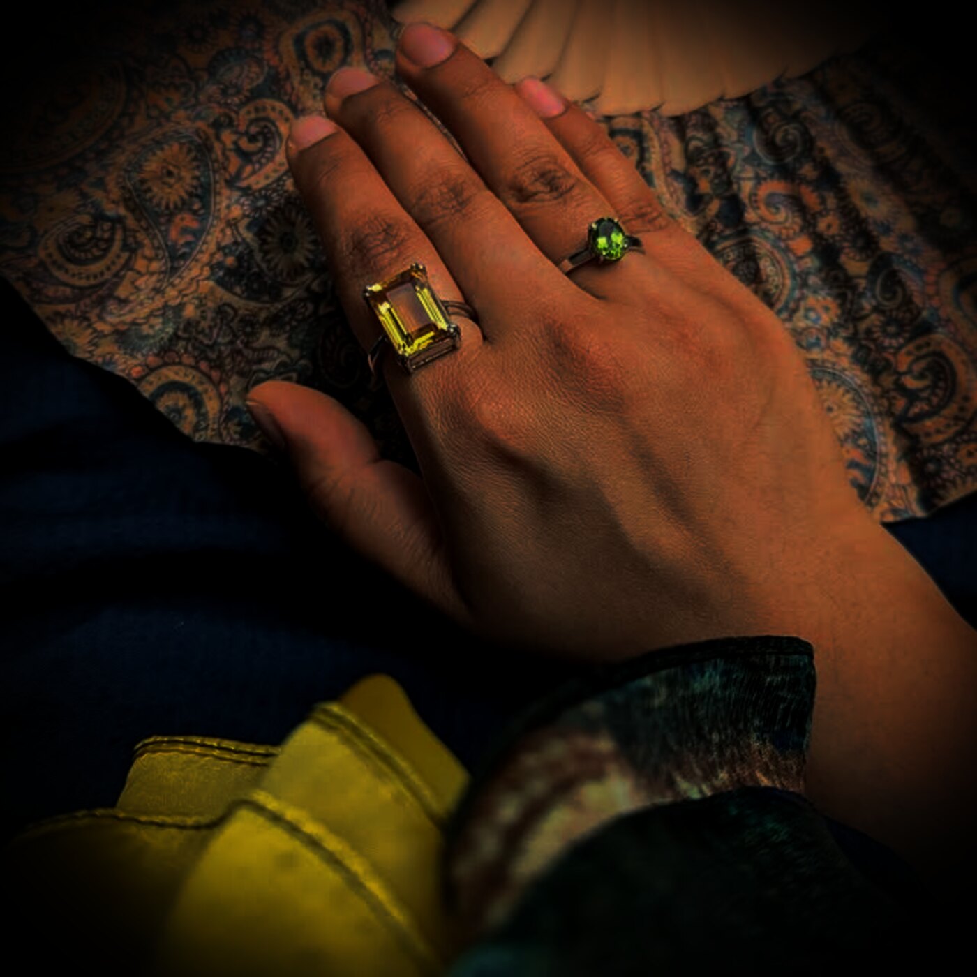 A citrine ring and peridot ring worn over patterned Jaipur silk.