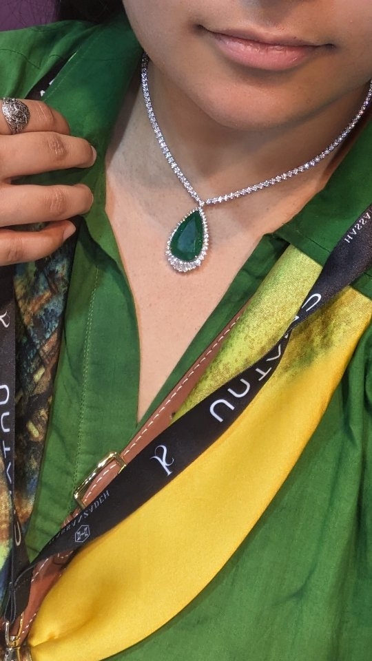 Pear-cut emerald and diamond pendant photographed at a London jewellery show
