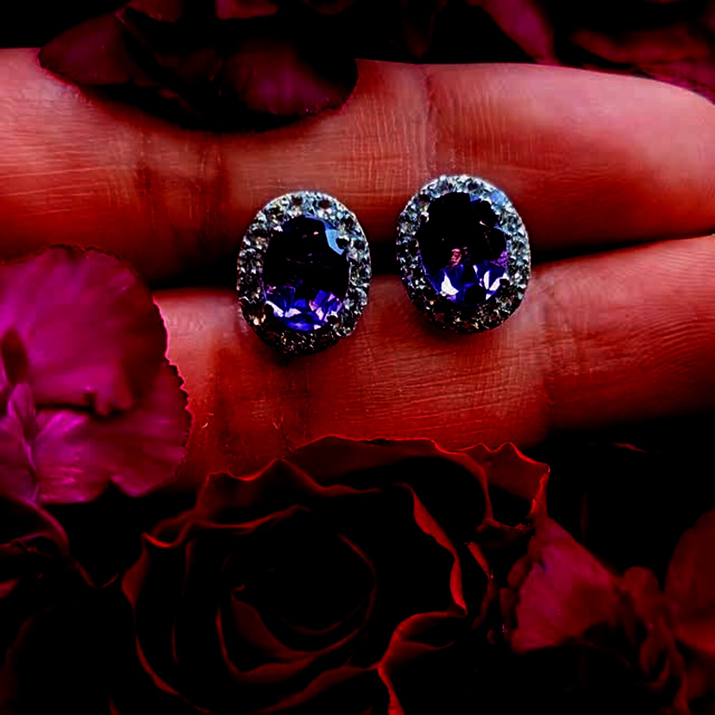 A pair of oval amethyst stud earrings haloed with smaller stones.