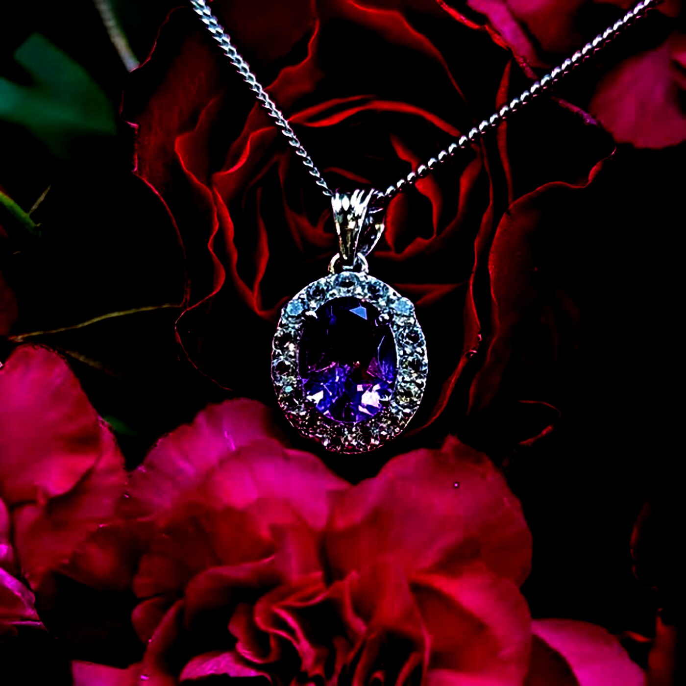 An oval amethyst pendant haloed with smaller stones on a fine chain.