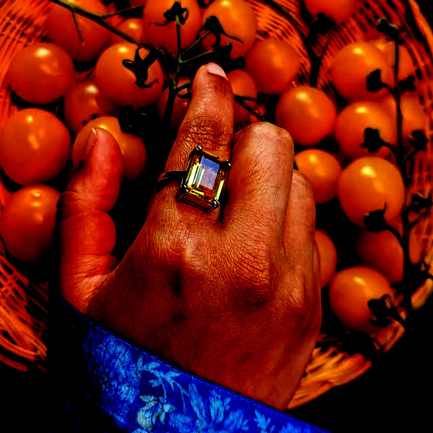 An emerald-cut citrine ring in gold, worn on the hand.